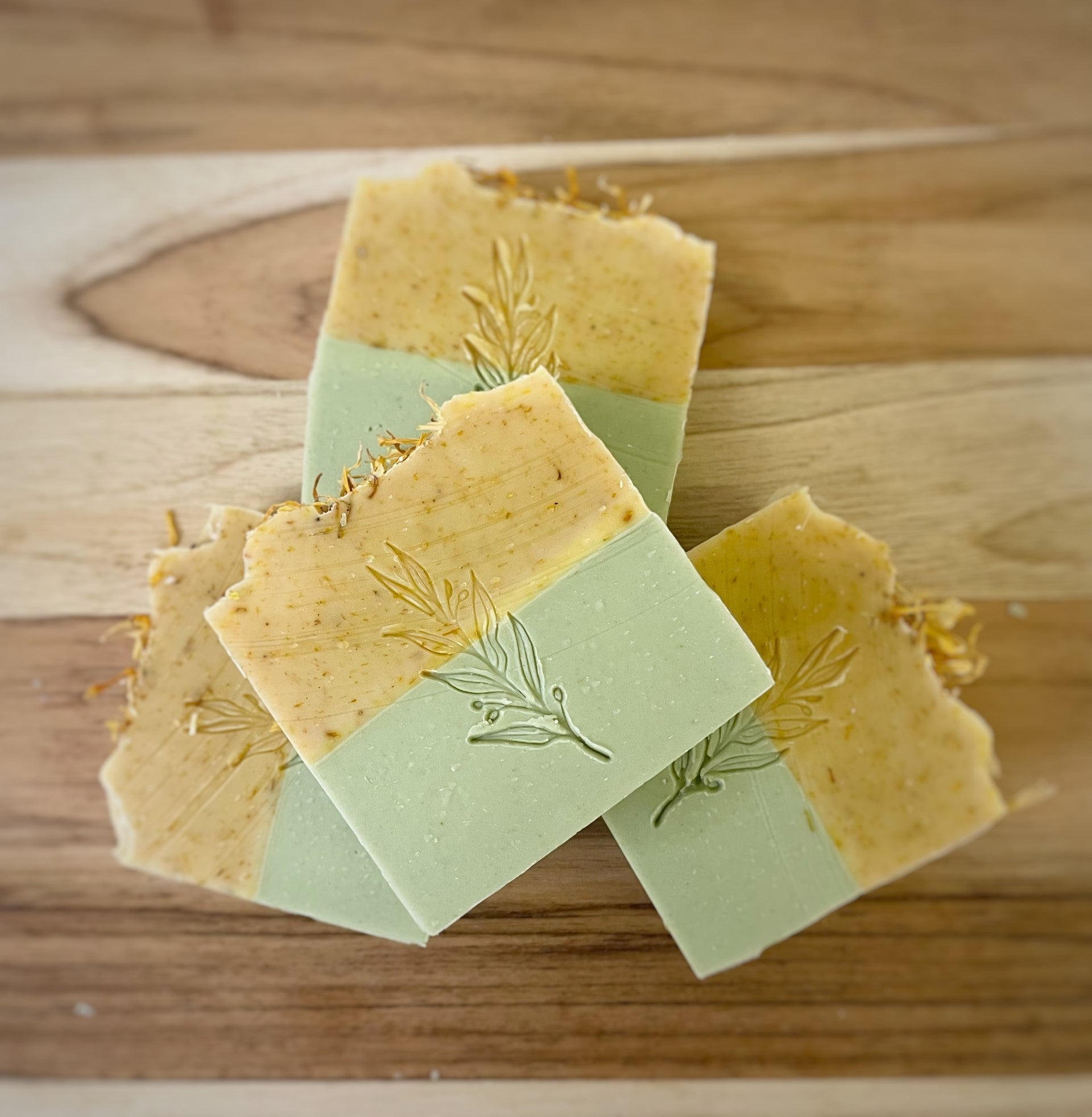 Artisanal handmade soaps with natural herbs, elegantly displayed on a wooden surface.